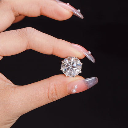 Person holding a VVS Moissanite 0.5-12ct 8 Prong Stud Earrings showcasing its brilliant sparkle.